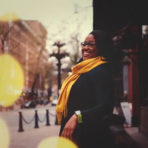 Editorial portrait of Tiffany Carey Jones in a Detroit street scene, wearing a yellow scarf